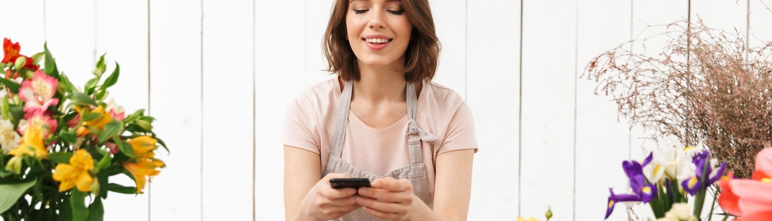 beautiful-florist-woman-apron-working-flower-taking-photo-with-mobile-phone-bouquet-table (1)